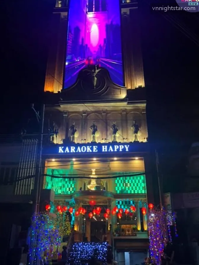 밤에 불이 켜진 건물 정면, 입구 위 KARAOKE HAPPY 간판과 홍등