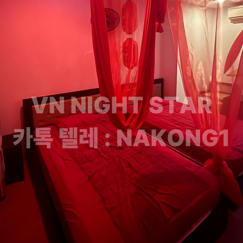 다낭 밤문화 업소 객실, 붉은 조명 아래 침대와 시스루 캐노피