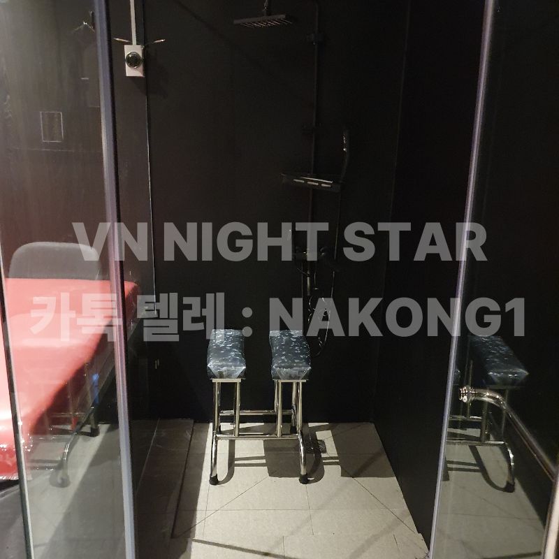 유리문으로 구분된 샤워 부스와 안에 놓인 스테인리스 스툴