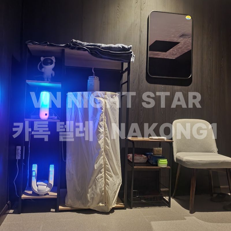 탈의 공간에 놓인 옷걸이 선반과 거울, 조명 소품이 놓인 진열대