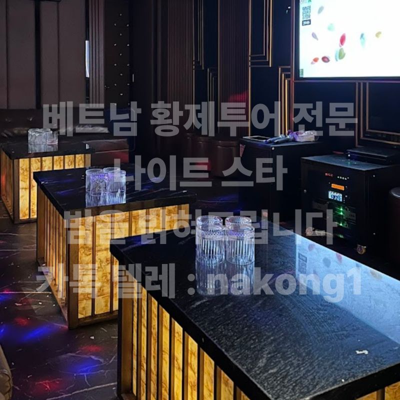 빈 잔이 놓인 테이블 너머로 대형 화면과 노래방 기기가 보이는 룸 안쪽