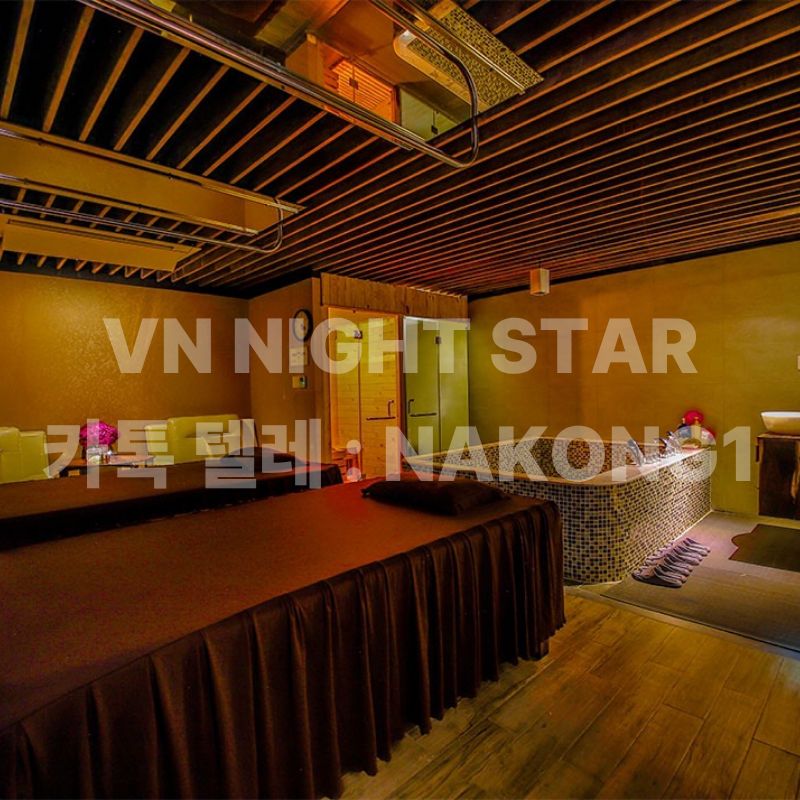 어두운 조명 아래 넓은 매트와 모자이크 타일 욕조가 놓인 방