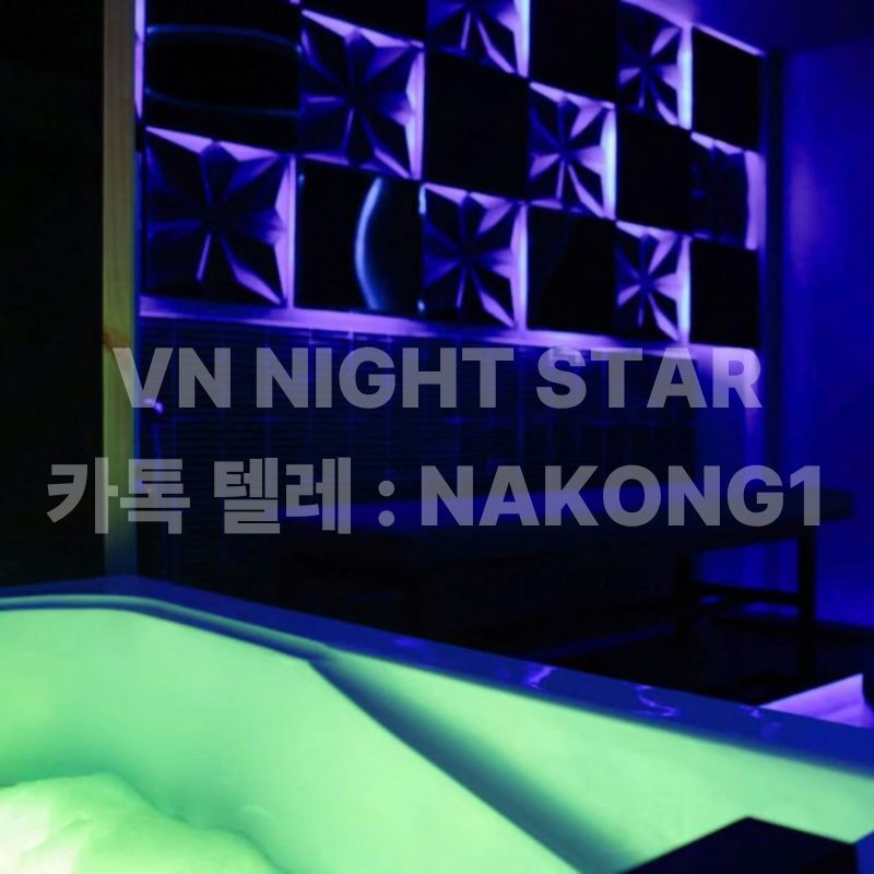 초록빛 조명이 비치는 욕조와 패턴 타일 벽