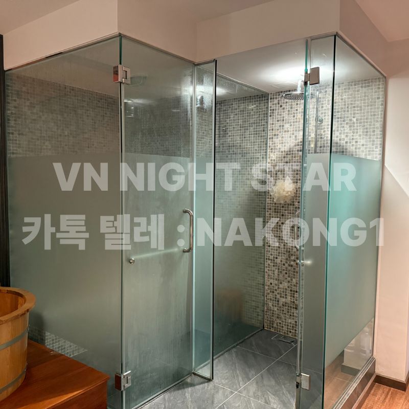 유리로 구획한 샤워 부스 두 칸과 모자이크 타일 벽