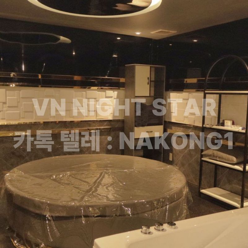 천장 원형 조명 아래 원형 침대와 수건장, 욕조가 있는 넓은 관리실