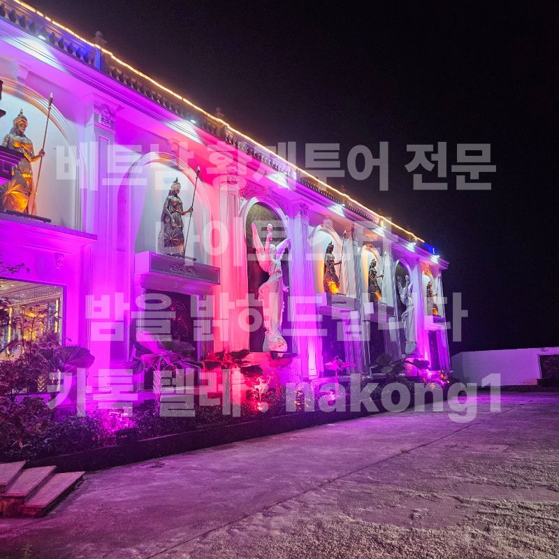 보라색 조명이 들어온 건물 측면과 늘어선 조각상