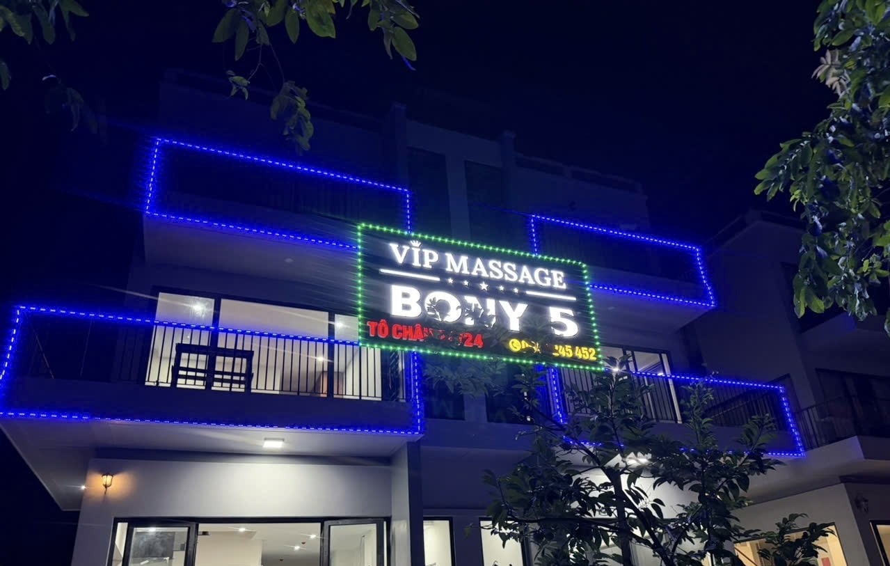 야간 파란 조명을 두른 건물 외벽과 VIP MASSAGE BONY 5 간판